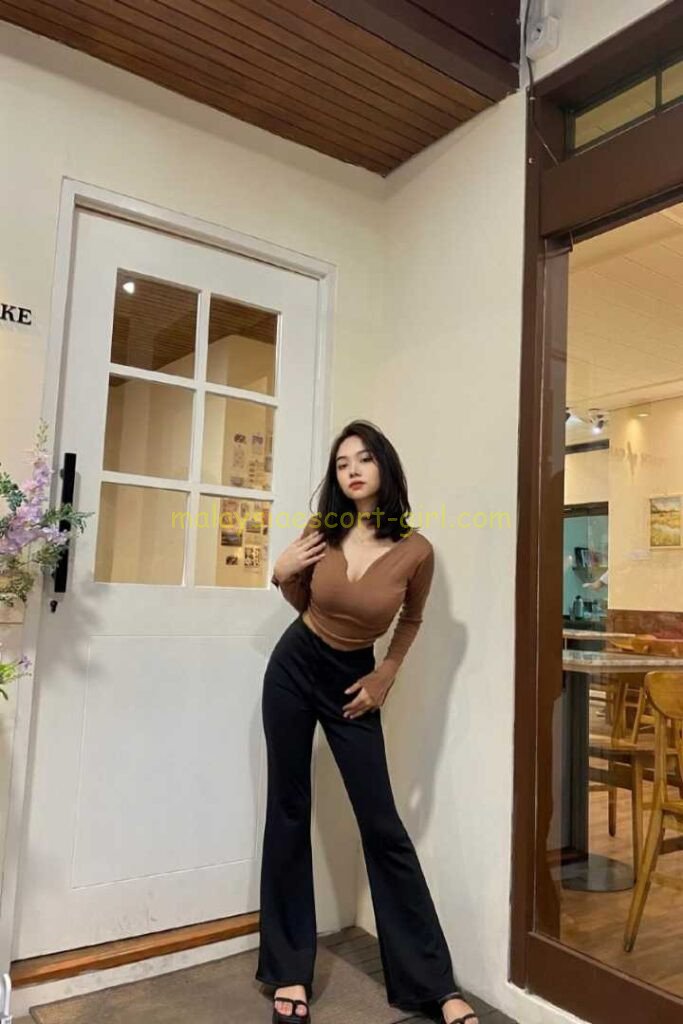 Qistina, a Malay Malaysia Escort, poses in black pants and a brown top. KL Escort Girl ready for KL Girl Service.