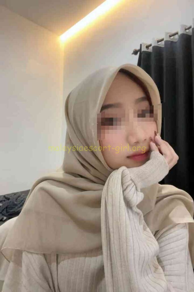 Woman in hijab adjusting her scarf, smiling with blurred face