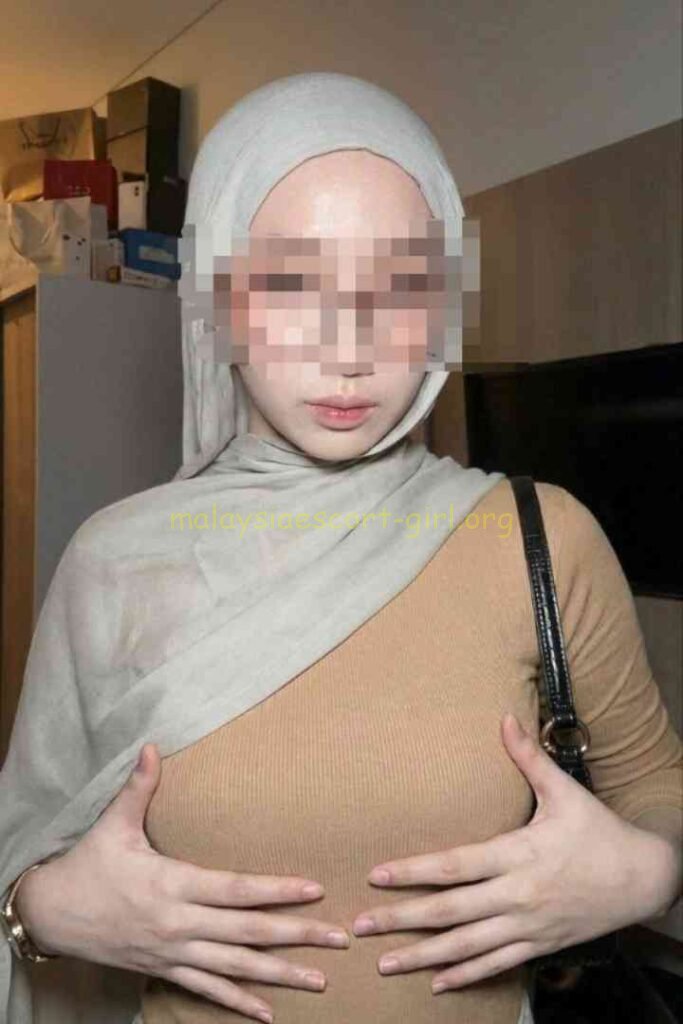 KL Escort Girl posing in a room, showing her breasts, wearing a hijab