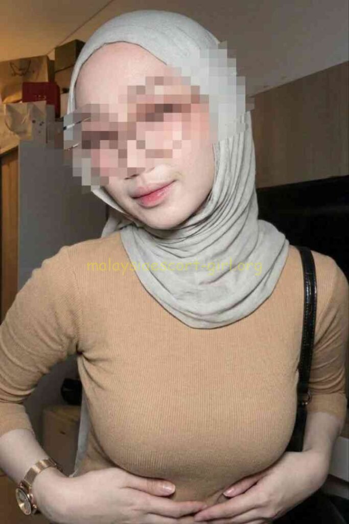 KL Escort Girl Kesya with hijab holding her stomach in beige top